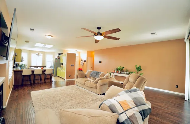 a living room with furniture kitchen view and a large window
