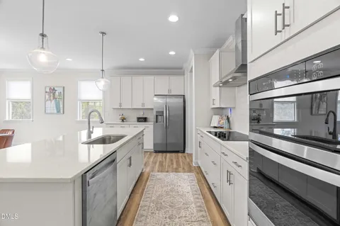 a kitchen with stainless steel appliances granite countertop a stove and a wooden floors