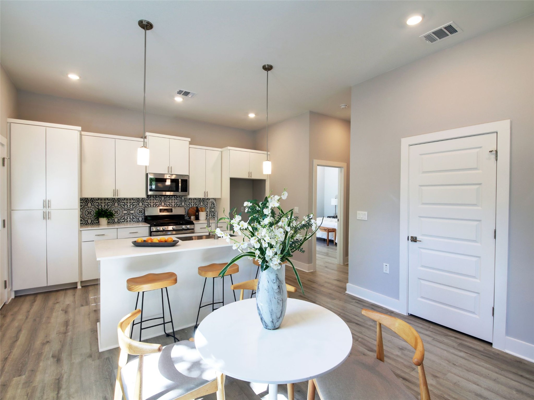 6111 Carnation Terrace, Unit 1 Austin, TX 78741 - Photo 11 of 23 a kitchen with stainless steel appliances kitchen island granite countertop a refrigerator a stove a microwave oven a dining table with wooden floor