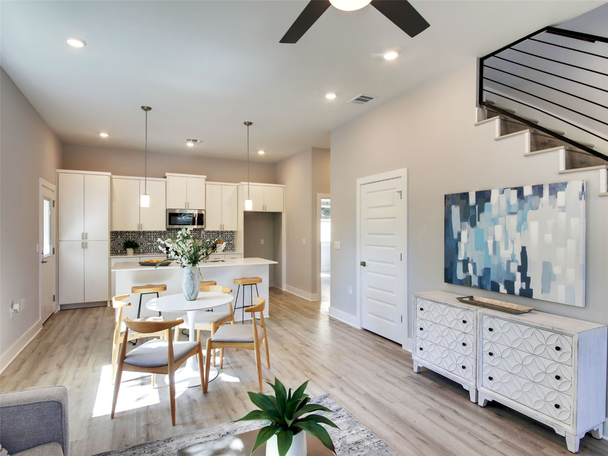 6111 Carnation Terrace, Unit 1 Austin, TX 78741 - Photo 9 of 23 a kitchen with stainless steel appliances kitchen island granite countertop a refrigerator a stove and white cabinets with wooden floor