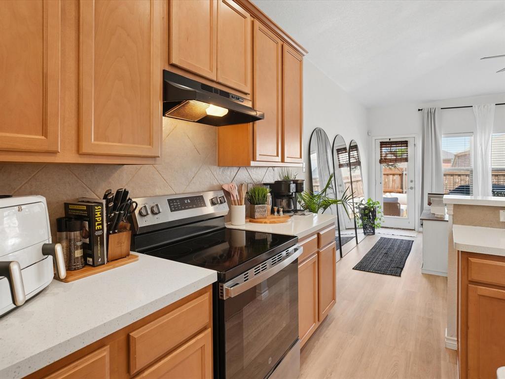 6527 Portside Ridge Lane Dallas, TX 75249 - Photo 12 of 30 a kitchen with granite countertop a stove and a sink