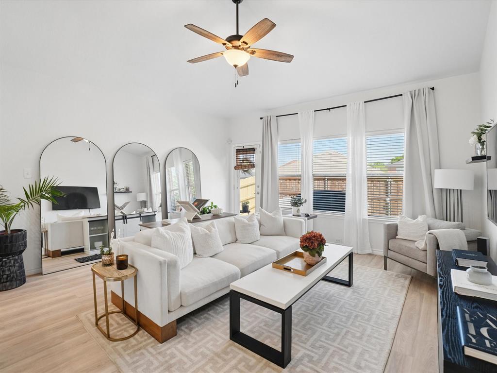 6527 Portside Ridge Lane Dallas, TX 75249 - Photo 18 of 30 a living room with furniture a fireplace and a chandelier