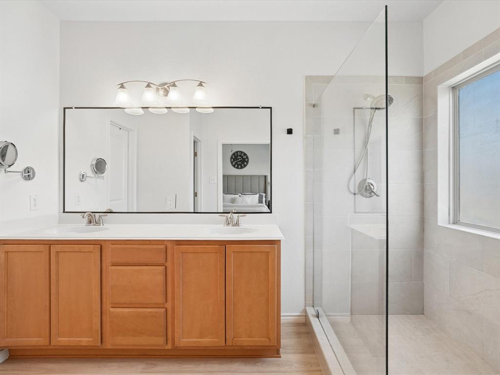 6527 Portside Ridge Lane Dallas, TX 75249 - Photo 20 of 30 a bathroom with a sink a mirror and a shower