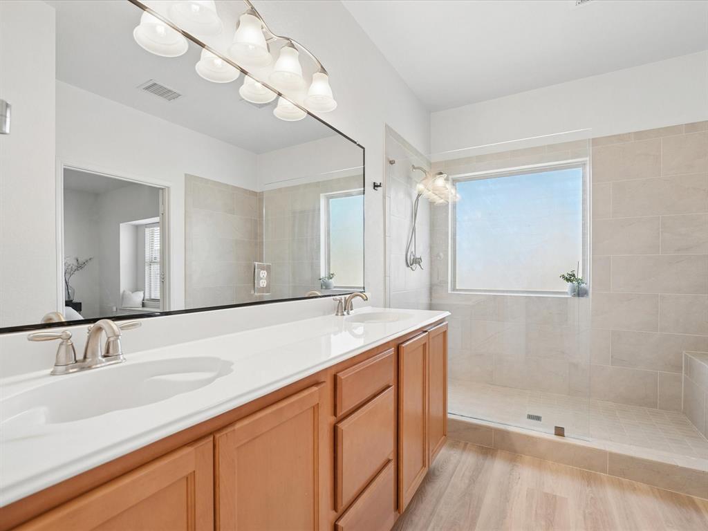 6527 Portside Ridge Lane Dallas, TX 75249 - Photo 22 of 30 a bathroom with a sink double vanity and a shower