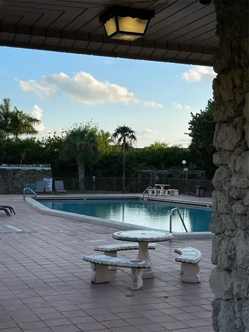 a view of swimming pool with lounge chair and dinning table