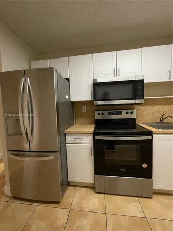 a kitchen with cabinets and steel stainless steel appliances