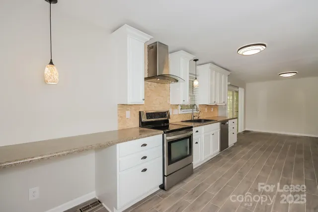 a kitchen with granite countertop a stove and cabinets