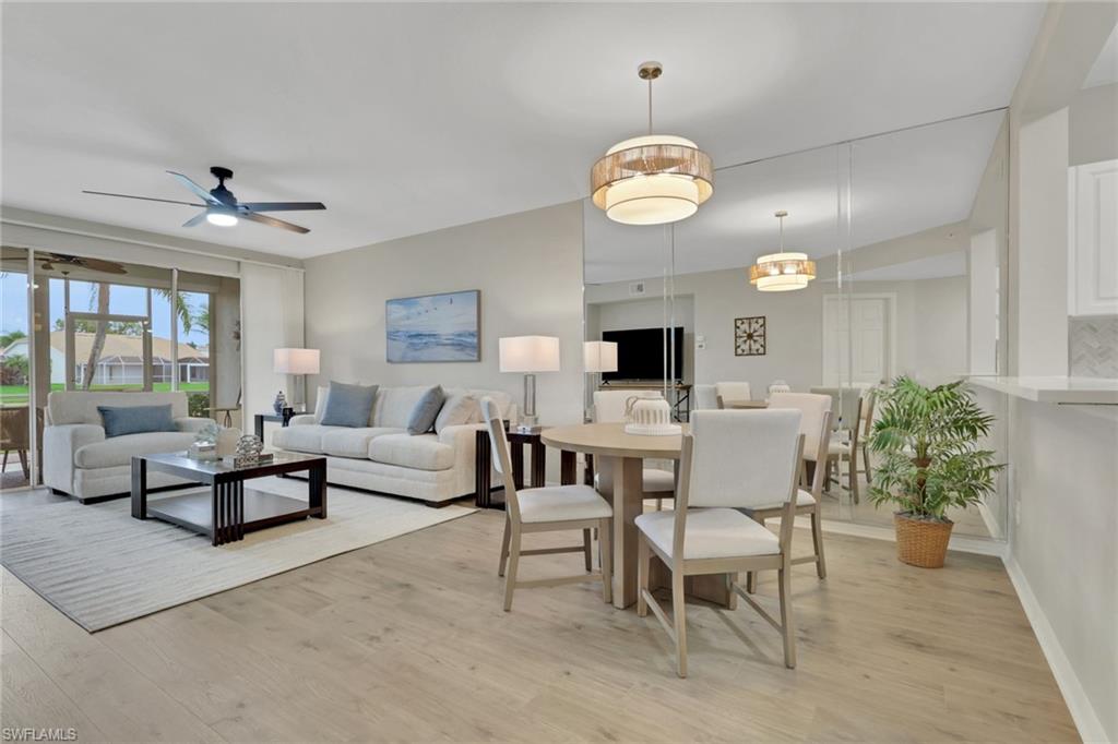 a living room with furniture kitchen view and a large window