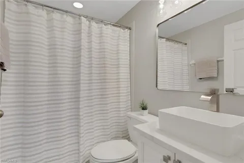 a bathroom with a sink a toilet and shower curtain