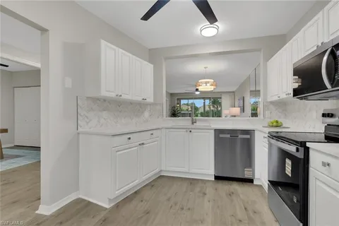 a kitchen with white cabinets appliances and sink