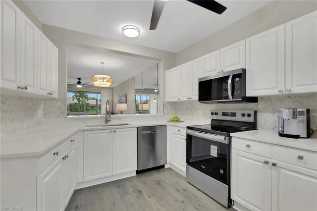 a kitchen with sink a microwave and cabinets