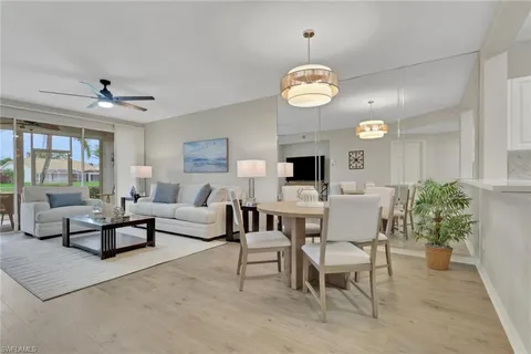 a living room with furniture kitchen view and a large window