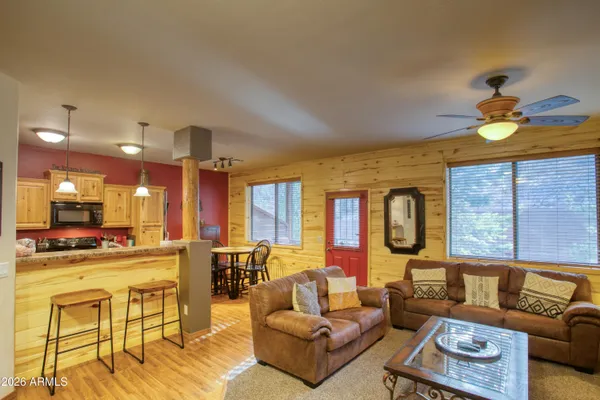 a living room with furniture kitchen view and a large window