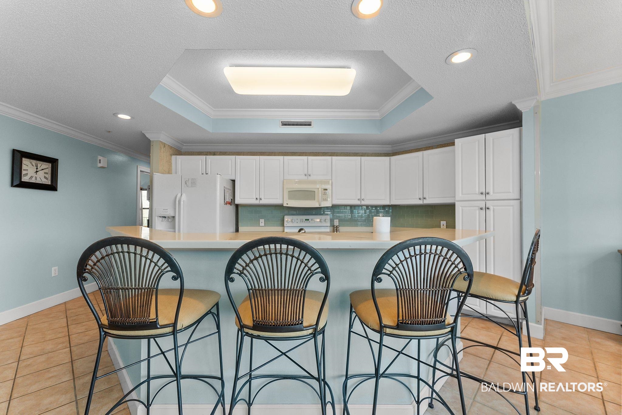 27580 Canal Road, Unit 1427 Orange Beach, AL 36561 - Photo 20 of 38 Kitchen with light countertops, tasteful backsplash, light tile patterned floors, white cabinetry, and white appliances