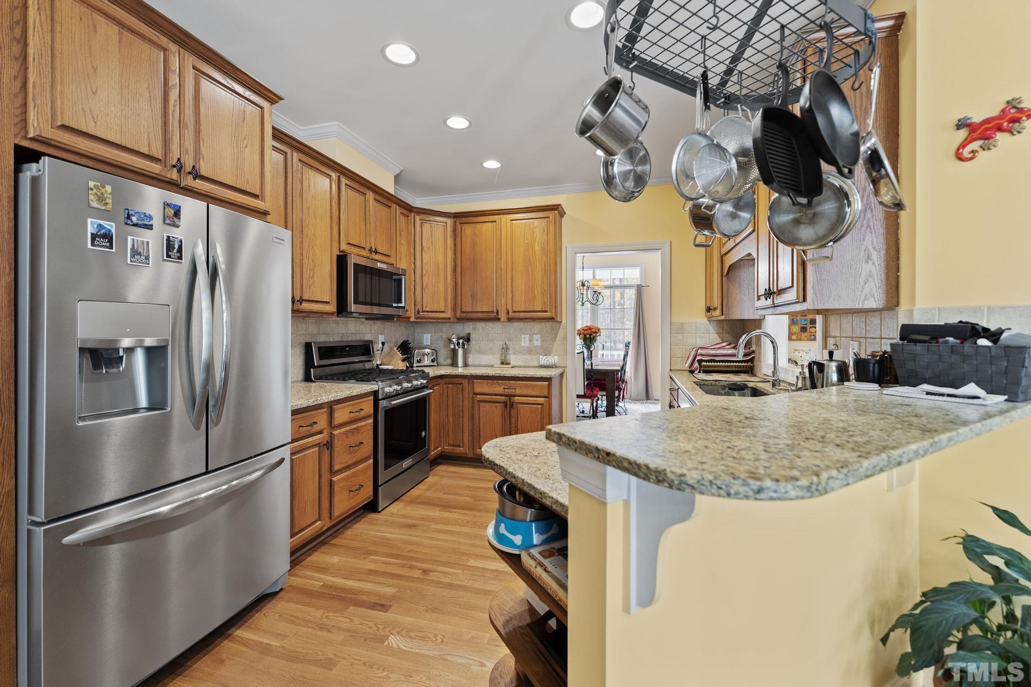 25 Eaglefeather Path Youngsville, NC 27596 - Photo 9 of 36 a kitchen with stainless steel appliances granite countertop a sink a stove and a refrigerator
