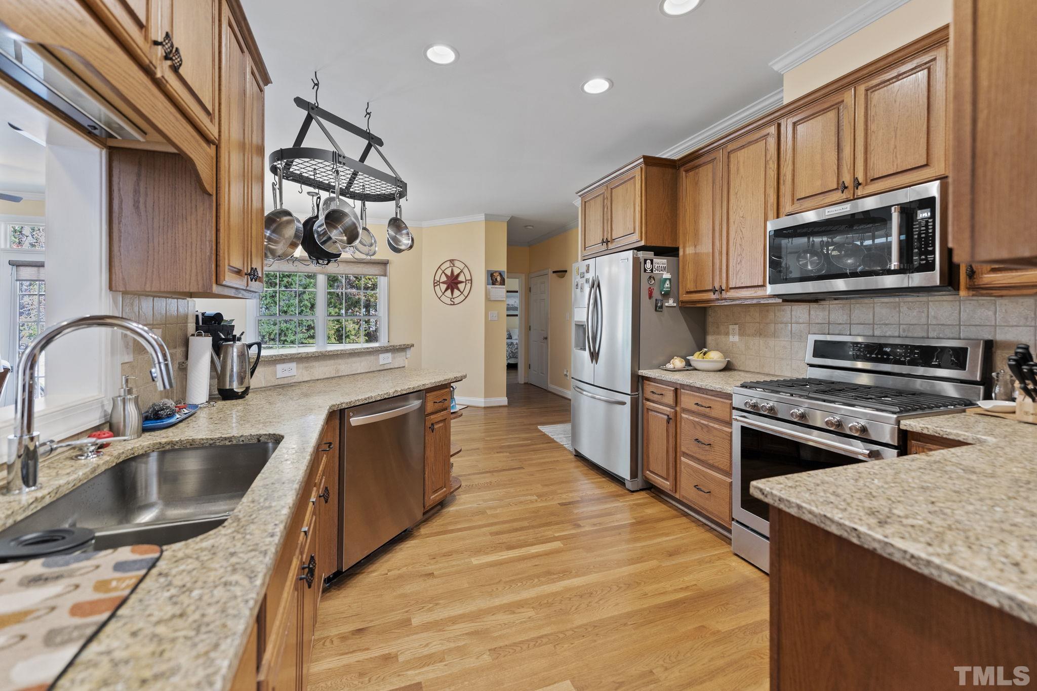 25 Eaglefeather Path Youngsville, NC 27596 - Photo 10 of 36 a kitchen with stainless steel appliances granite countertop a sink a stove top oven a refrigerator cabinets and a kitchen island