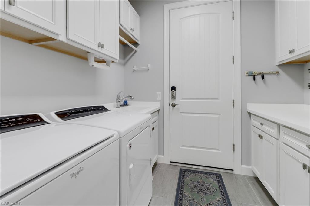 14236 Moonlit Way Estero, FL 33928 - Photo 24 of 46 a utility room with cabinets washer and dryer