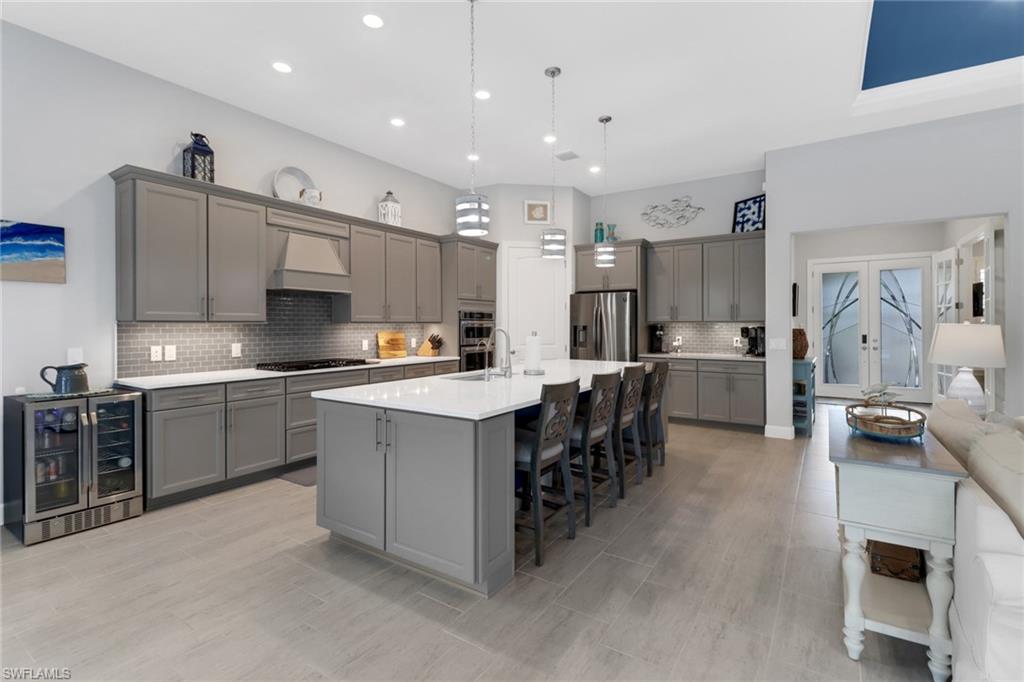 14236 Moonlit Way Estero, FL 33928 - Photo 6 of 46 a large kitchen with kitchen island a sink a counter and stainless steel appliances