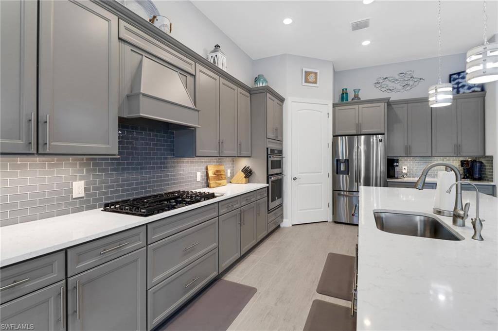 14236 Moonlit Way Estero, FL 33928 - Photo 7 of 46 a kitchen with stainless steel appliances granite countertop a sink and cabinets