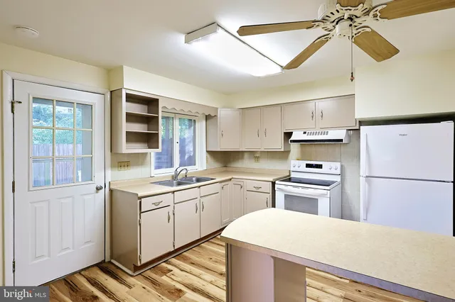a kitchen with a sink a stove and white cabinets