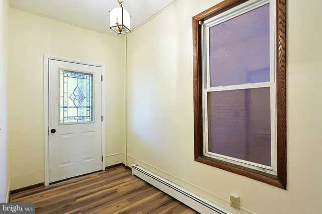 a view of a hallway with wooden floor and entryway