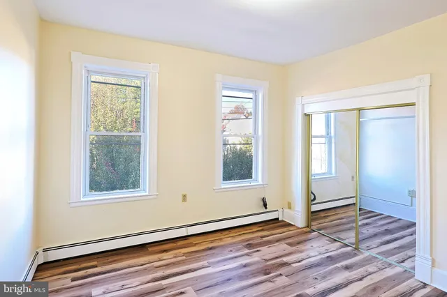 a view of a room with wooden floor and a window