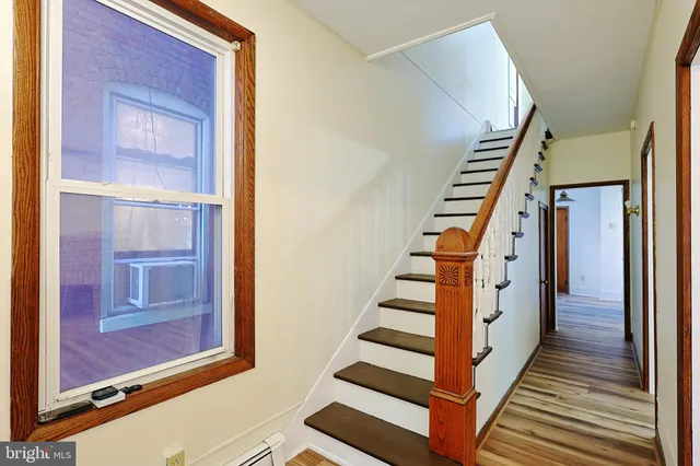 a view of a hallway with wooden floor and windows