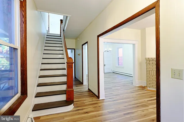 a view of a livingroom with wooden floor and a fireplace