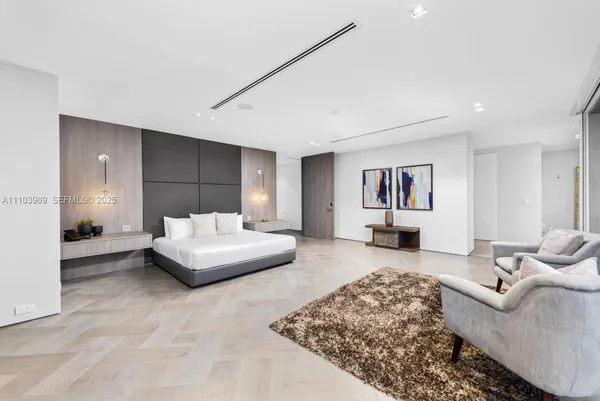 a large bedroom with a bed and wooden floor