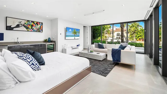 a bedroom with a bed couch painting on wall and a flat screen tv