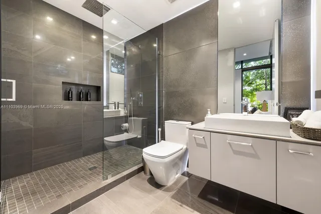 a bathroom with a sink a toilet and shower