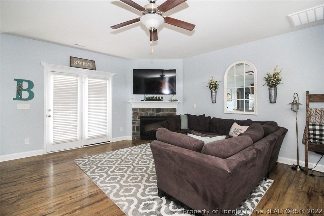 3549 Thrower Road Hope Mills, NC 28348 - Photo 6 of 38 a living room with furniture a flat screen tv and a fireplace