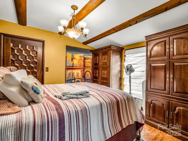 a bedroom with a bed next to a window