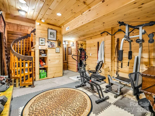 a view of a dining room with furniture a chandelier and large windows