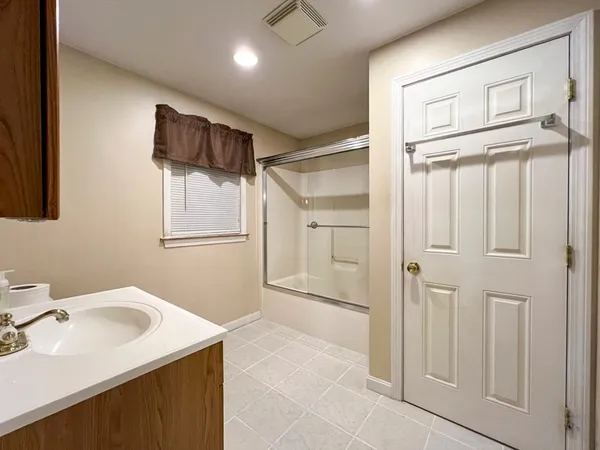 a bathroom with a sink a glass door shower and a mirror