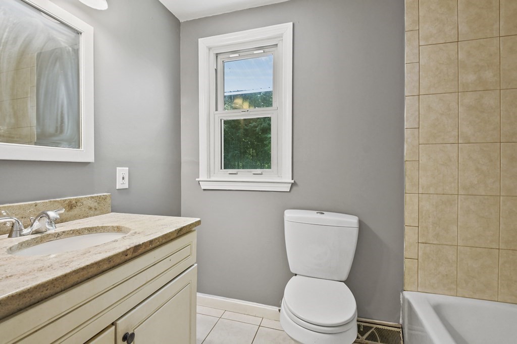 40 Orton Street Worcester, MA 01604 - Photo 22 of 28 a bathroom with a granite countertop toilet sink and mirror