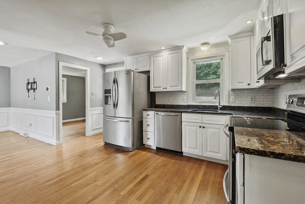 40 Orton Street Worcester, MA 01604 - Photo 7 of 28 a kitchen with stainless steel appliances granite countertop a refrigerator a sink dishwasher a stove and white countertops with wooden floor