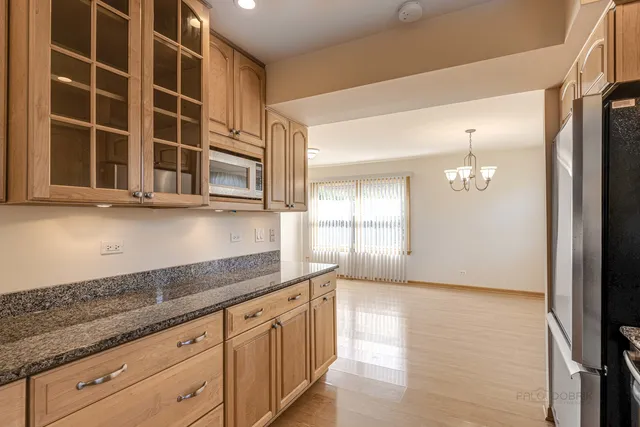 a kitchen with granite countertop white cabinets and stainless steel appliances