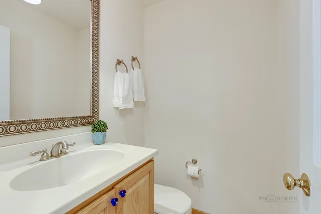 a bathroom with a sink vanity mirror and toilet