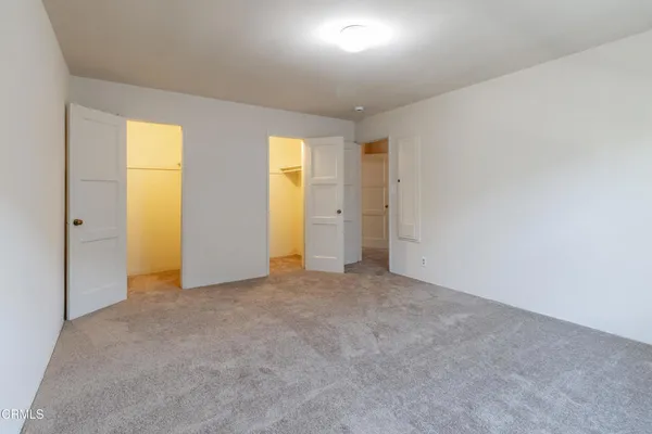 an empty room with windows and closet