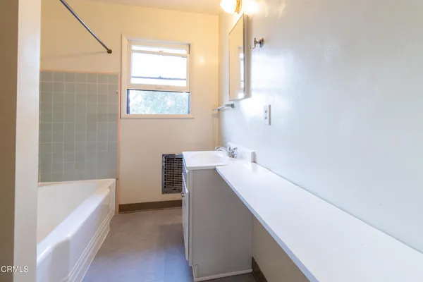 a bathroom with a bathtub sink and mirror