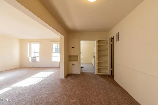an empty room with closet and windows