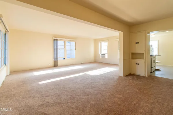 an empty room with windows and bathroom view