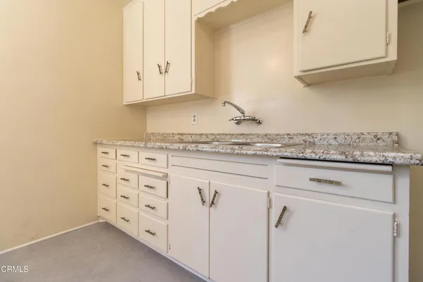 a kitchen with granite countertop white cabinets and white appliances