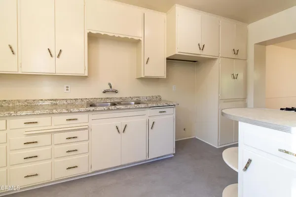 a view of cabinets a sink and a stove in a kitchen