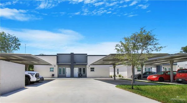 a front view of a house with a big yard and potted plants