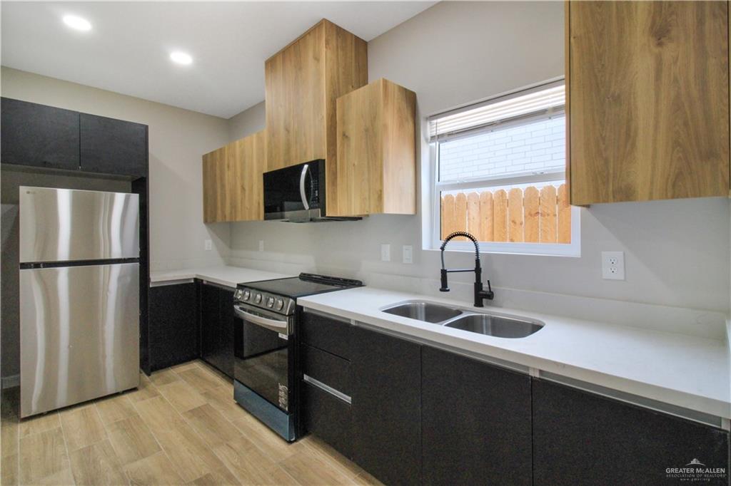810 South Athol Street, Unit 1 Pharr, TX 78577 - Photo 2 of 15 a kitchen with a refrigerator and a sink