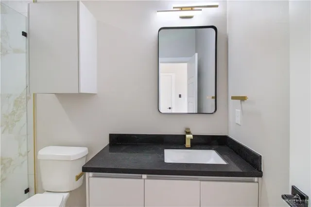 a bathroom with a toilet a sink and mirror