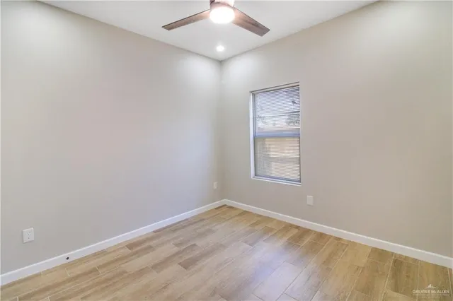 an empty room with a window and wooden floor