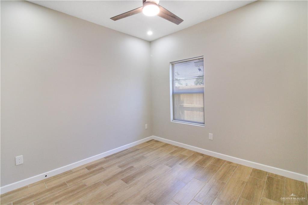 810 South Athol Street, Unit 1 Pharr, TX 78577 - Photo 7 of 15 an empty room with a window and wooden floor